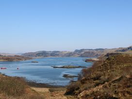 A coastal landscape with hills water and boats at WildLuing in Cullipool Isle Of Luing