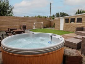 A garden with a hot tub and dining area at 51 Trinity Avenue, Llandudno