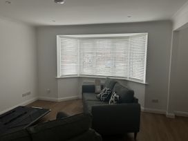 A living room with a sofa and window blinds at 40 Gloddaeth View in Llandudno