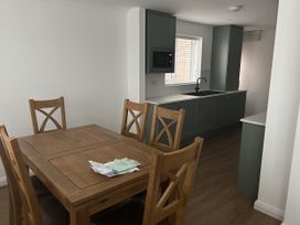 A dining room with a table and chairs adjacent to a kitchen at 40 Gloddaeth View in Llandudno