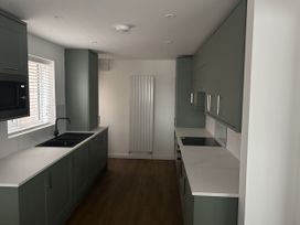 A kitchen with cabinets and appliances at 40 Gloddaeth View in Llandudno