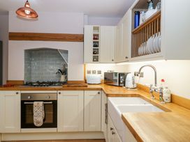 A kitchen with wooden countertops a stove oven sink and cabinets at 2 Loxter Villas in Wellington Heath near Ledbury