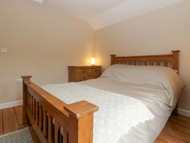 A bedroom with a wooden bed and chest of drawers at 2 Loxter Villas Wellington Heath near Ledbury