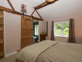 A bedroom with a bed and wooden door at 2 Loxter Villas Wellington Heath near Ledbury
