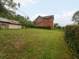 A view of a house and shed in a grassy area at 2 Loxter Villas Wellington Heath near Ledbury