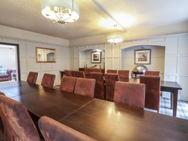A dining room with two dark wood tables and brown upholstered chairs at Dragon House Bilbrook near Minehead
