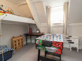A game room with a foosball table and a loft bed with toys at Dragon House in Bilbrook near Minehead