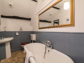 A bathroom with a bathtub a toilet and a sink with a large mirror above at Dragon House in Bilbrook near Minehead