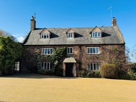 A stone house with multiple windows and ivy on the walls at Dragon House in Bilbrook near Minehead