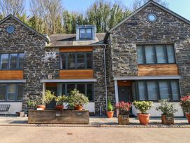 Exterior view of a stone house with planters at 8 Pottery Cottages
