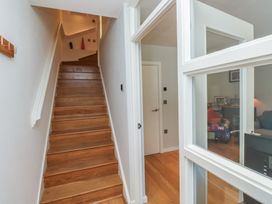 A hallway with stairs and a door at 8 Pottery Cottages