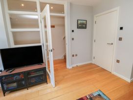 A living room with a television and cabinet at 8 Pottery Cottages