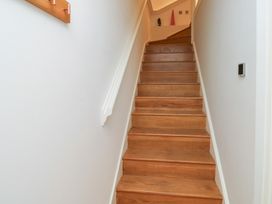 A staircase with wooden steps and a handrail at 8 Pottery Cottages