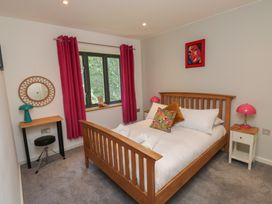 A bedroom with a bed and desk at 8 Pottery Cottages