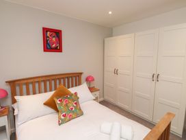 A bedroom with a bed and wardrobe at 8 Pottery Cottages 