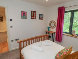 A bedroom with a bed and artworks on the wall at 8 Pottery Cottages 