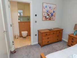 A bedroom with a wooden dresser and bathroom in view at 8 Pottery Cottages