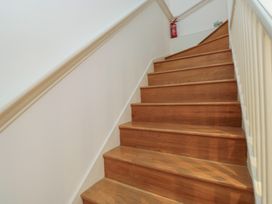 A staircase with wooden steps and a fire extinguisher at 8 Pottery Cottages in 