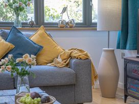 A living room with a sofa and decorative items at Mariners Retreat, 8 Pottery Cottages, Dartmouth
