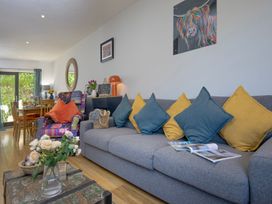 A living room with a sofa and dining area at Mariners Retreat, 8 Pottery Cottages in Dartmouth