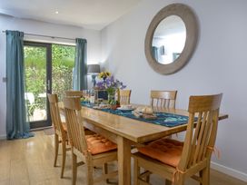 A dining room with a wooden table and chairs at Mariners Retreat, 8 Pottery Cottages, Dartmouth