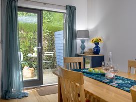 A dining room with a table and chairs at Mariners Retreat, 8 Pottery Cottages in Dartmouth
