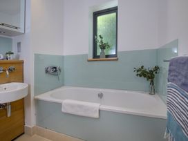 A bathroom with a bathtub and sink at Mariners Retreat, 8 Pottery Cottages in Dartmouth