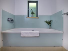 A bathroom with a bathtub and a window at Mariners Retreat, 8 Pottery Cottages in Dartmouth