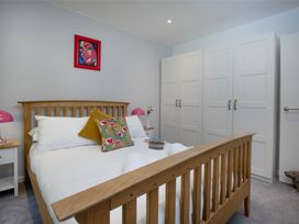 A bedroom with a bed and wardrobe at Mariners Retreat, 8 Pottery Cottages Dartmouth