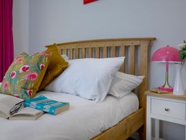 A bedroom with a wooden bed and bedside table at Mariners Retreat, 8 Pottery Cottages, Dartmouth