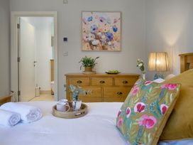 A bedroom with a bed and a wooden dresser at Mariners Retreat, 8 Pottery Cottages, Dartmouth