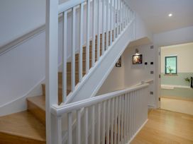 A hallway with staircase and bathroom door at Mariners Retreat, 8 Pottery Cottages Dartmouth