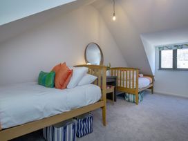 A bedroom with two beds and a mirror at Mariners Retreat, 8 Pottery Cottages, Dartmouth