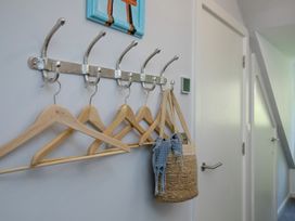 A hallway with coat hooks and a woven basket at Mariners Retreat, 8 Pottery Cottages, Dartmouth