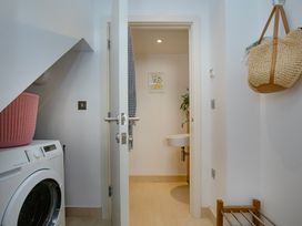 A laundry room with a washing machine and a sink at Mariners Retreat, 8 Pottery Cottages in Dartmouth