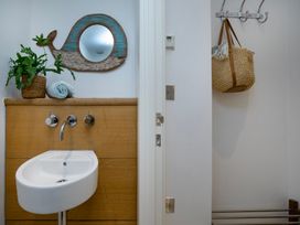 A bathroom with a sink and wall hooks at Mariners Retreat, 8 Pottery Cottages in Dartmouth