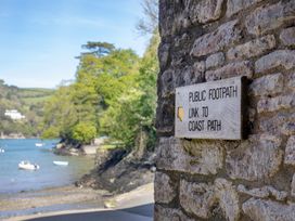 A public footpath sign leading to the coast path near a waterway in Dartmouth