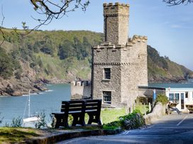 A castle near the water with a bench at Mariners Retreat, 8 Pottery Cottages, Dartmouth