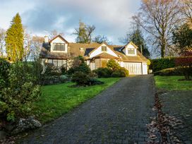 A house with a driveway and garden at Marina View in Bowness-On-Windermere