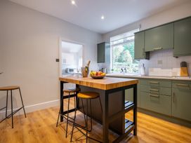 A kitchen with an island bar and stools at Marina View in Bowness-On-Windermere