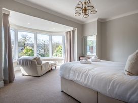 A bedroom with a bed and a chair at Marina View in Bowness-On-Windermere