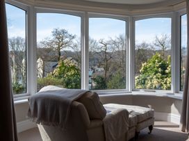 A living room with a chair and window view at Marina View Bowness-On-Windermere