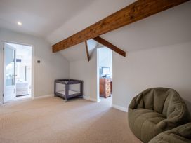 A loft with a playpen, bean bag, and television at Marina View in Bowness-On-Windermere