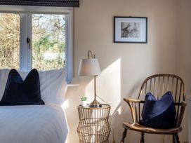 A bedroom with a bed and chair at Marina View in Bowness-On-Windermere