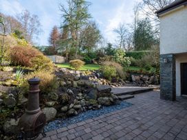 A garden with a stone path and seating area at Marina View in Bowness-On-Windermere