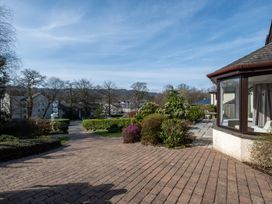 A garden with a pathway and flower beds at Marina View in Bowness-On-Windermere