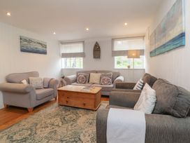 A living room with sofas a wooden coffee table a patterned rug and wall art at Gatekeeper's Cottage in Bilbrook near Minehead