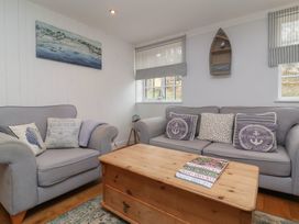 A sitting room with grey sofas and cushions and a wooden coffee table at Gatekeeper's Cottage in Bilbrook near Minehead