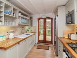 A kitchen with wooden countertops and double wooden doors at Gatekeeper's Cottage in Bilbrook near Minehead