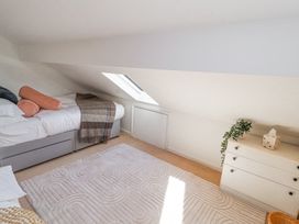 A bedroom with a bed, dresser with a plant and tissue box, and a skylight window at High Wood Foot in Bampton, Cumbria